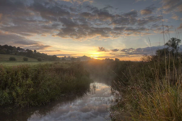 River Brue, at dawn with Glastonbury Tor in background, Somerset, UK, August