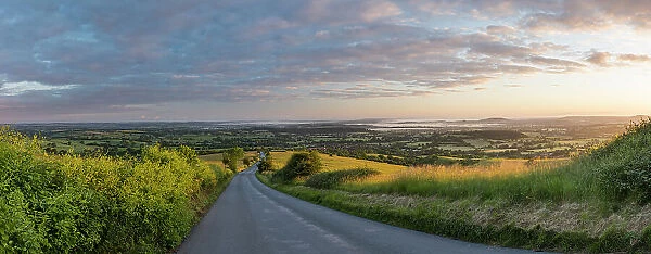 The road to Okeford Fitzpaine; dawn on Midsummers Day, in the Blackmore Vale, from Okeford Hill, Dorset, England, UK. June 2019