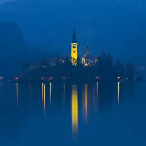 Assumption of Mary Pilgrimage Church, in twilight, reflected in Lake Bled, Bled, Slovenia