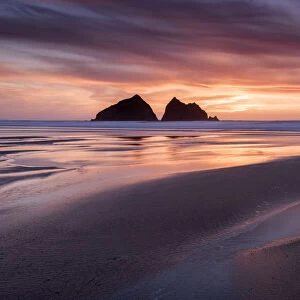 Holywell Bay at sunset, at low tide with Carters Rocks reflected in water