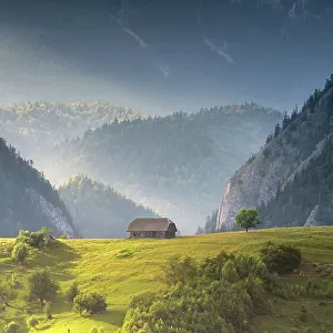 Traditional barn on hilltop in mountain landscape, Magura, Brasov County, Carpathian mountains, Romania. July, 2021