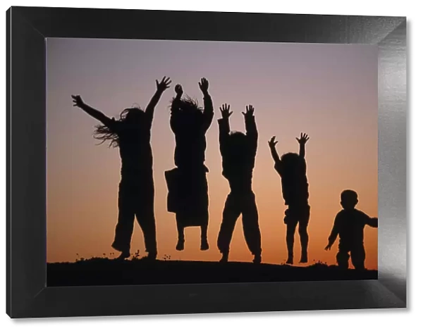 Silhouette of five leaping Children, Bohuslan archipelago, Sweden