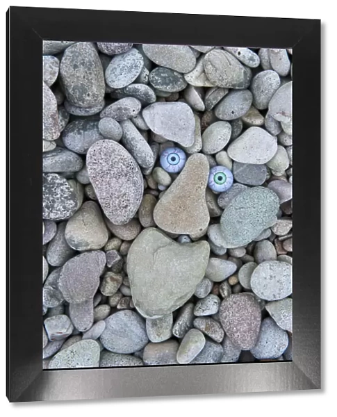 Troll face amongst beach pebbles, Claggain Bay, Islay, Scotland