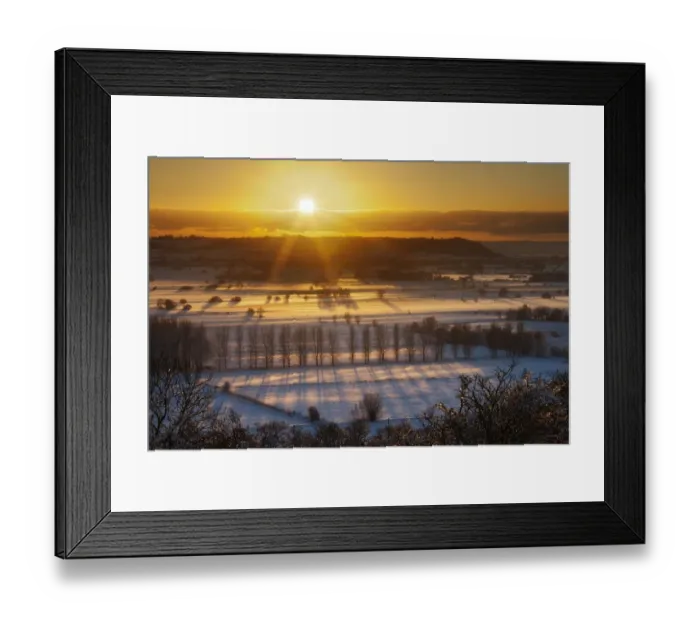Framed Print : Winter sunset over the Somerset Levels from Walton Hill on a misty evening with snow on the ground Framed Print : Winter sunset over the Somerset Levels from Walton Hill on a misty evening with snow on the ground