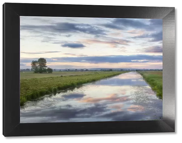Sunrise with reflection of clouds in Kings Sedgemoor Drain, Greylake, Somerset Levels