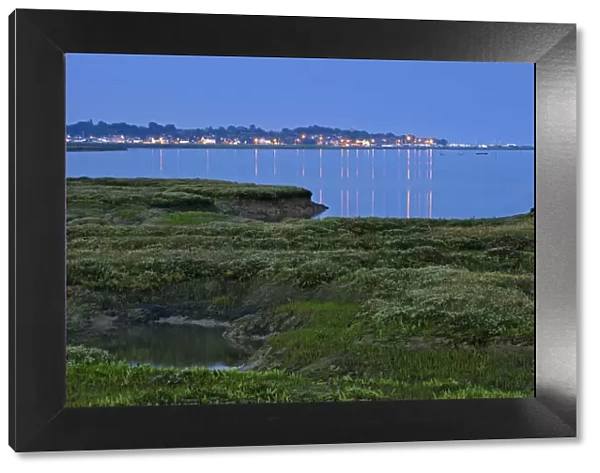 Saltmarsh at twilight, with lights of Bradwell-on-Sea in the background, Abbotts