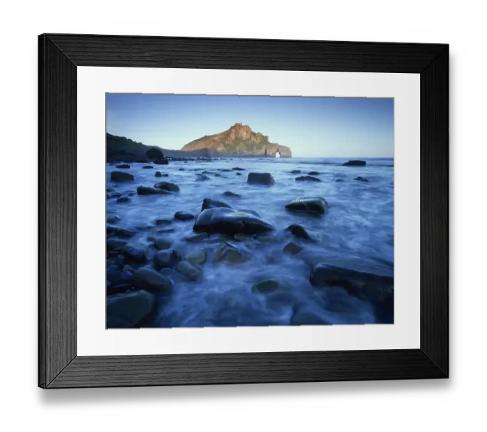 Framed Print : Sea over smooth rocks with rock arch in distance, Gaztelugatxe coast, Basque country