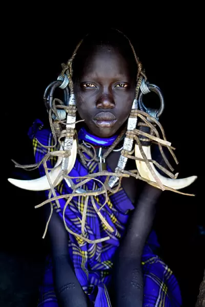 Young girl in traditional dress. Mursi tribe, Mago National Park. Omo Valley, Ethiopia
