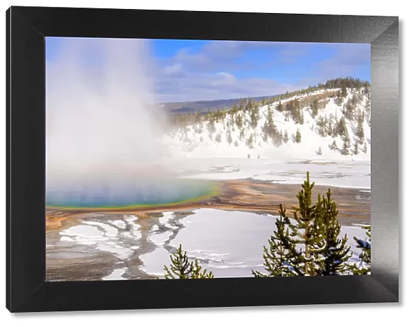 Steam rising from Grand Prismatic thermal pool in snow covered landscape. Midway Geyser Basin
