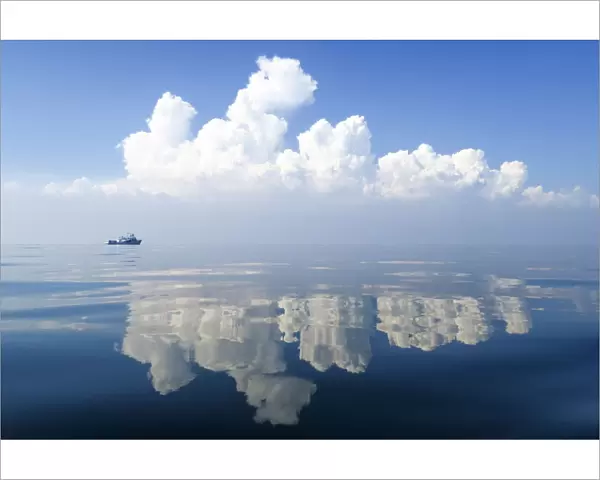 Small boat on calm waters with reflections of cloud formations, Gulf of Thailand, Pacific