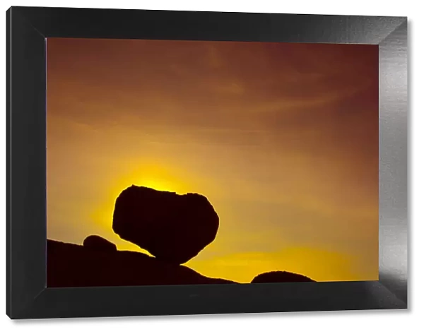 Huge boulder balanced on rocky outcrop at sunset, Namib desert