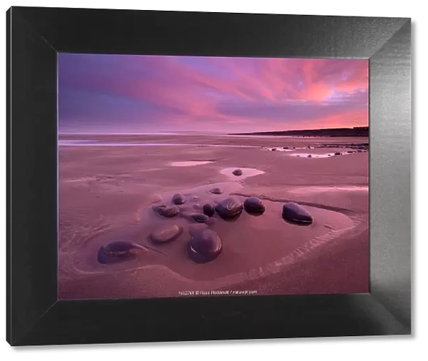 Westward Ho! beach at sunrise, colourful sky at low tide and tidal pool, north Devon, UK