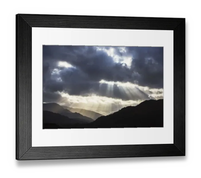 Framed Print : Sun rays shining through clouds onto Loughrigg Fell and hills of the Lake District Framed Print : Sun rays shining through clouds onto Loughrigg Fell and hills of the Lake District