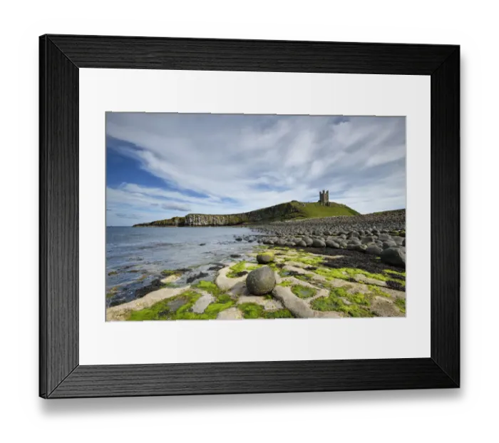 Framed Print : Dunstanburgh Castle on headland of the Whin Sill, eroded dolerite boulders in foreground Framed Print : Dunstanburgh Castle on headland of the Whin Sill, eroded dolerite boulders in foreground