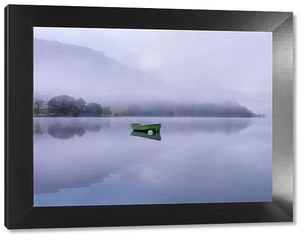Rowing boat on Ullswater in early morning mist, Lake District, Cumbria, England, UK. November 2015