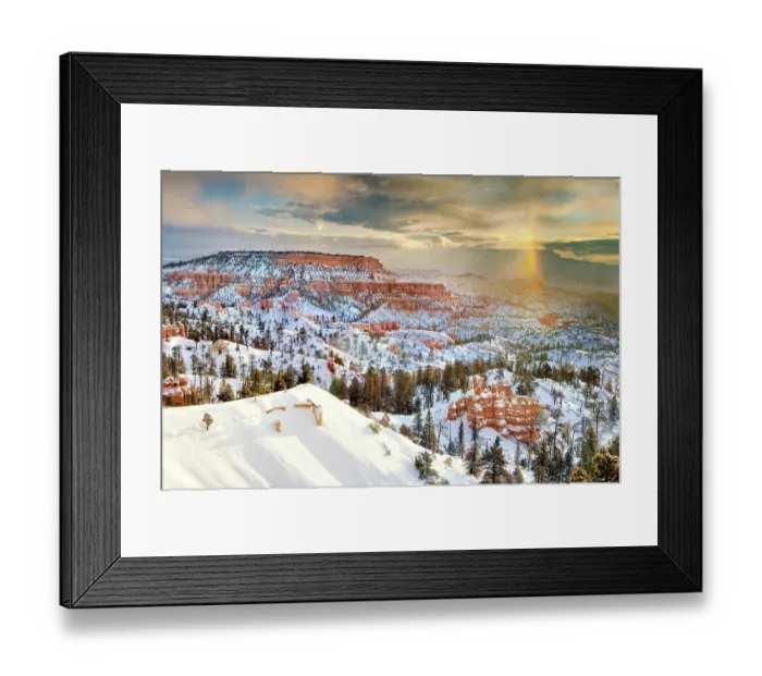 Framed Print : A snow bow forming over the snow-covered red sandstone hoodoos and geological formations in a high desert habitat during a winter sunrise, Bryce Canyon National Park, Utah, USA
