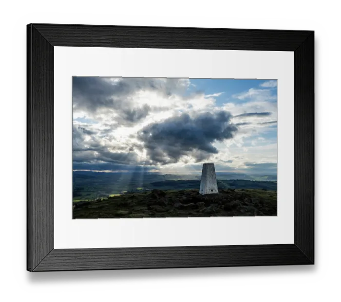 Framed Print : Titterstone Clee Hill summit and the trig point and shafts of sunlight emerging from dark clouds, Shropshire Hills National Landscape, England, UK. April, 2024 Framed Print : Titterstone Clee Hill summit and the trig point and shafts of sunlight emerging from dark clouds, Shropshire Hills National Landscape, England, UK. April, 2024