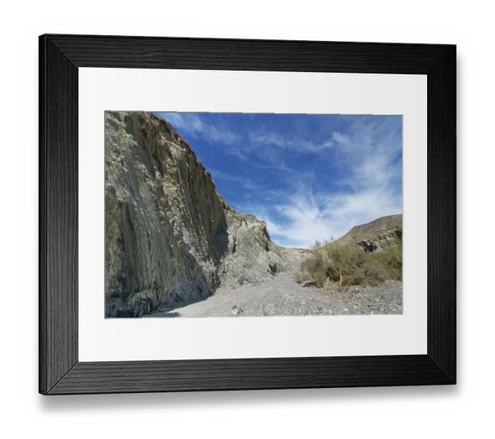 Framed Print : Dry river bed flanked by cliffs of eroded sandstone and shale turbidite layers eroded by seasonal water flow, Tabernas Desert, Almeria, Spain. March, 2024 Framed Print : Dry river bed flanked by cliffs of eroded sandstone and shale turbidite layers eroded by seasonal water flow, Tabernas Desert, Almeria, Spain. March, 2024