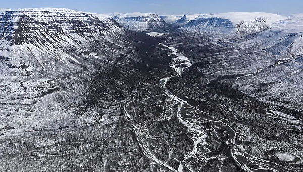 Aerial view of braided river running through valley on snow covered plateau, Putoransky State Nature Reserve, Putorana Plateau, Siberia, Russia. May, 2021