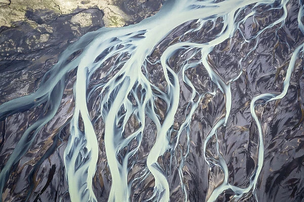 Aerial view of a glacier river flowing from glacier which is melting at an unprecedented pace due to rising temperatures and reduced snowfall, Vatnajookull Glacier, South Iceland. 29th May 2022