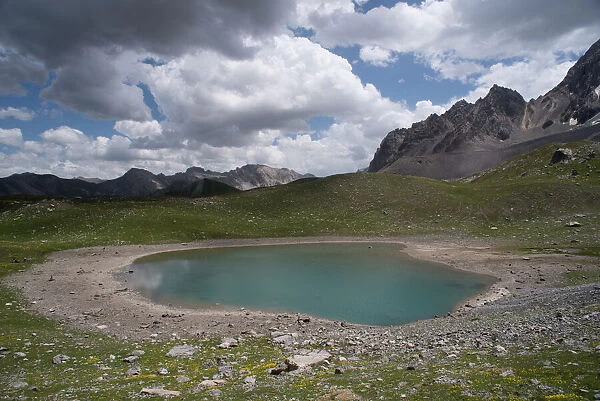 Alpine lake at an altitude of 2400 m, drying up during heatwave in summer, Lac des Rouites, Queyras, The Alps, France. 4th July, 2022