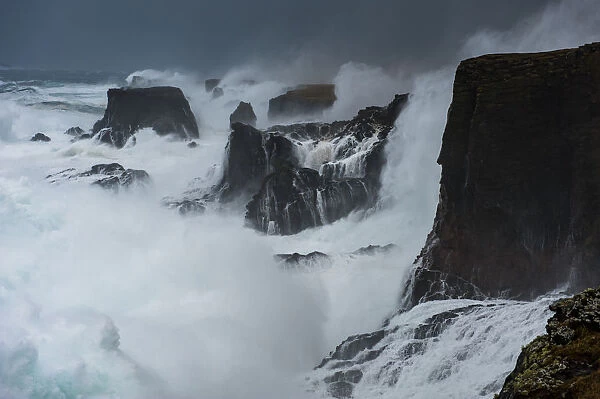 Big storm hitting cliffs, with waves breaking over the top, Shetland, Scotland, UK, July