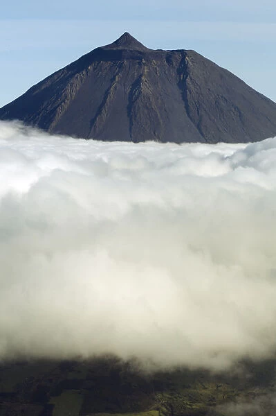 Clouds around Pico, the highest mountain in Portugal, sticking out through a loayer of clouds