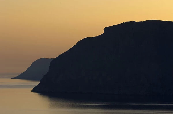 Coastal cliffs silhouetted at dawn near Mochlos, Crete, Greece, April 2009