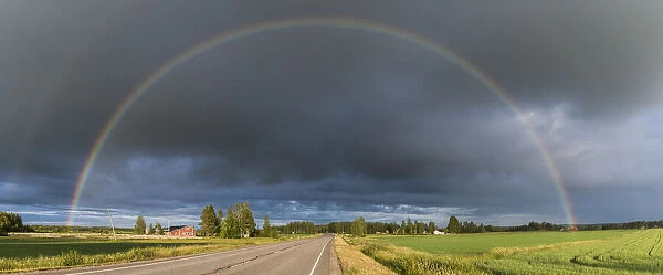 Double rainbow over road through countryside. Nivala, Northern Ostrobothnia, Finland