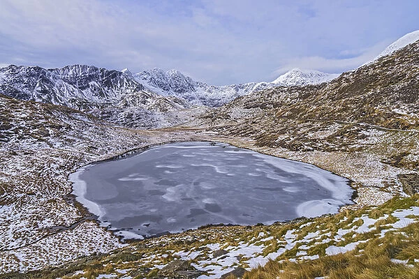 Frozen Llyn Teyrn with Y Llewydd and Mount Snowdon in background. View west from Miners Track