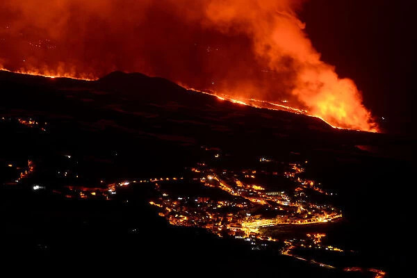 Lava flow and ash from erupting volcano passing close by the village of Los Llanos de Aridane, Volcano Cumbre en Vieja, La Palma, Canary Islands. November, 2021
