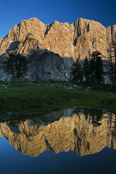 Mount Velika Mojstrovka (2, 056m) with reflection in a pool of water, Sleme, Triglav National Park