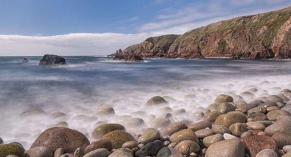 Pebbles on shoreline, cliffs along coast beyond. Bloody Foreland, Knockfola