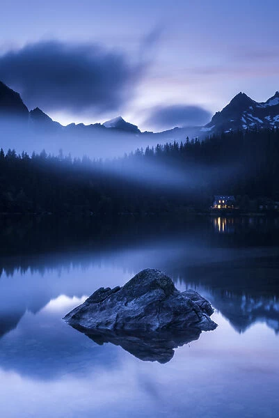 Popradske Pleso, looking toward mountain range, in late evening light, with reflections and mist