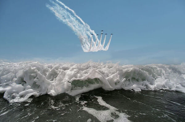 The Red Arrows display team flying in formation over the sea, Rhosneigr, Anglesey, Wales, UK. August, 2022