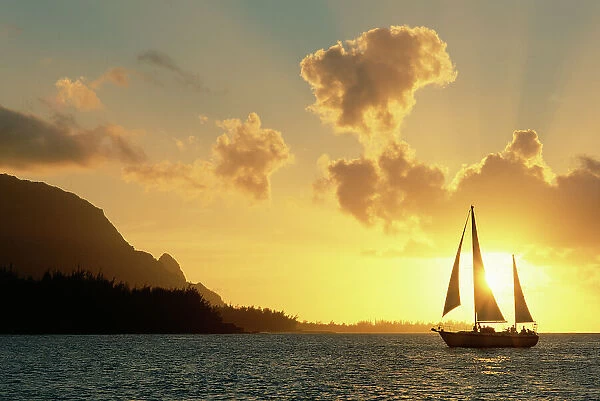 Sailing yacht at sunset off coast of Hanalai Bay, Kauai, Hawaii, USA
