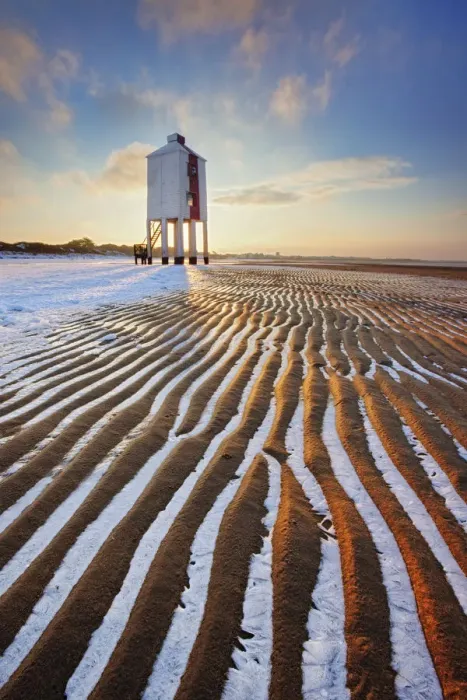 Framed Print : Sand patterns with ice between ripples of the sand, front of Burnham-on-Sea Lighthouse in winter