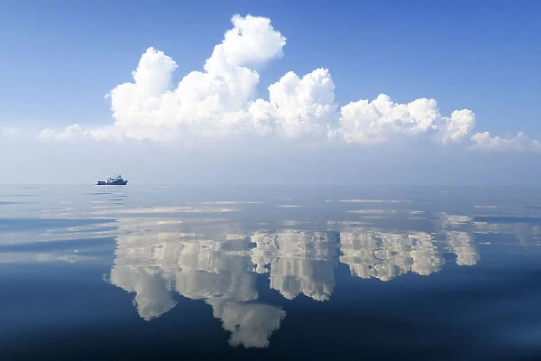 Small boat on calm waters with reflections of cloud formations, Gulf of Thailand, Pacific