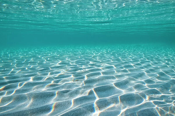 Sunbeams, refracted on a shallow seabed. Alghero, Sardinia, Italy. Mediterranean Sea