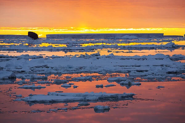 Sunset over sea ice in Weddell Sea, sky reflected in water