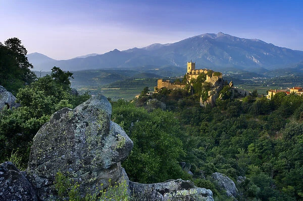 The village of Eus perched on a hilltop with sunlight with the Pic de Canigou beyond