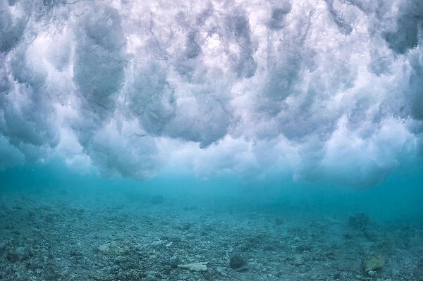 Wave breaking over the rubble zone close to the reef crest of a coral reef. Baa Atoll, Maldives. Indian Ocean