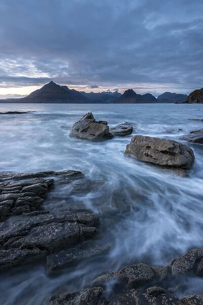 Waves washing up Elgol beach in the evening light with a view of the Cuillins, Strathaird