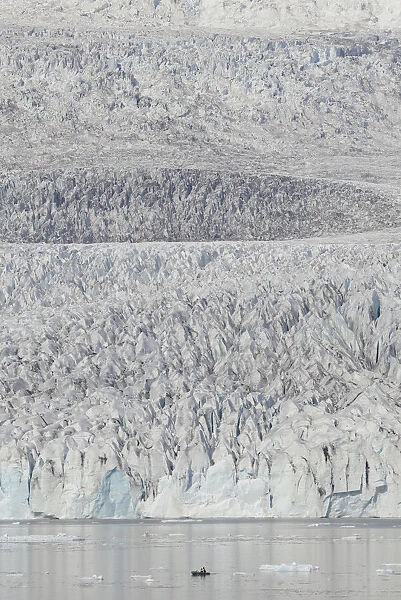 Zodiac carrying visitors navigating among ice floes at foot of Fjallsarlon Glacier, Iceland. July