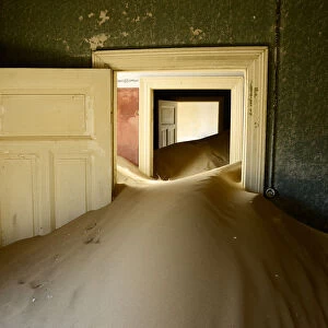 Abandoned house full of sand. Kolmanskop Ghost Town, an old diamond-mining town where