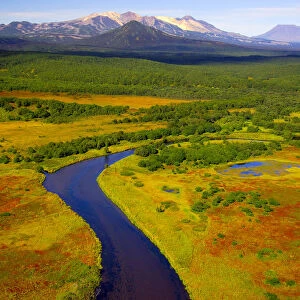 Aerial view of the Tikhaya River flowing through the colourful tundra in autumn. The Kikhpinich