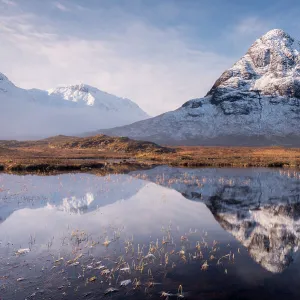 Buachaille Etive Beag reflected in Lochan na Fola after snowfall, early morning light, Glencoe, Scotland, UK. March 2017