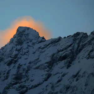 First light behind snow covered mountain near Dombay, Teberdinsky biosphere reserve