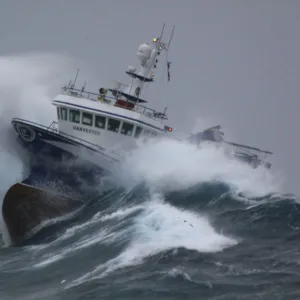 Fishing vessel Harvester powering through huge waves while operating in the North Sea