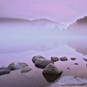 Mist over Coniston Water before dawn. Lake District, Cumbria, England
